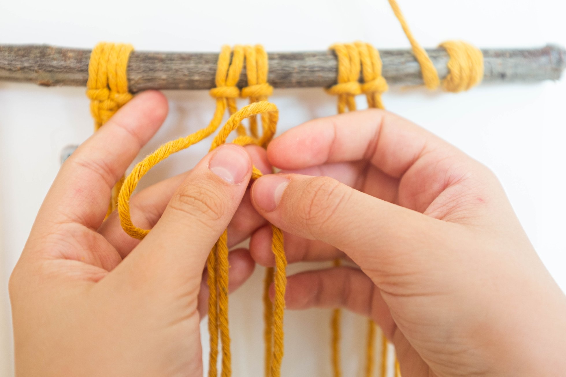 Hands doing macrame craft